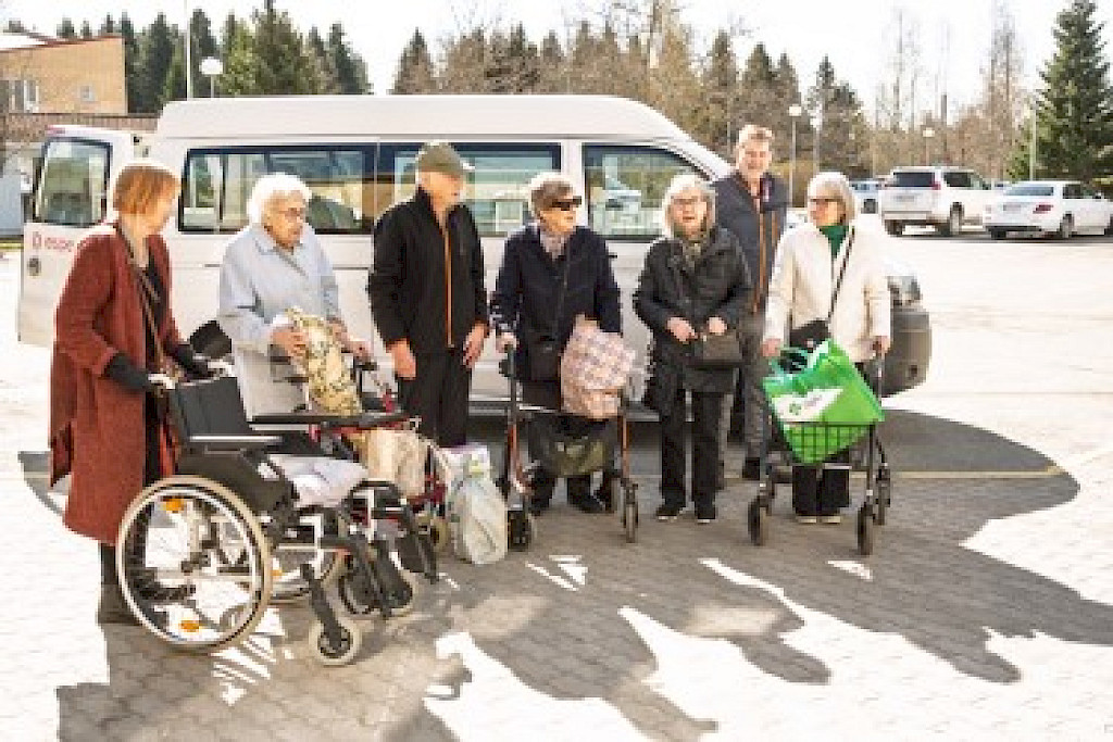Ostosreissulta palaavia asukkaita palvelukeskus Esperin pihalla.
