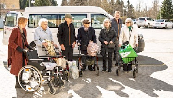 Ostosreissulta palaavia asukkaita palvelukeskus Esperin pihalla.