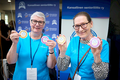 Iloiset vapaaehtoiset liiton esittelypöydän ääressä.
