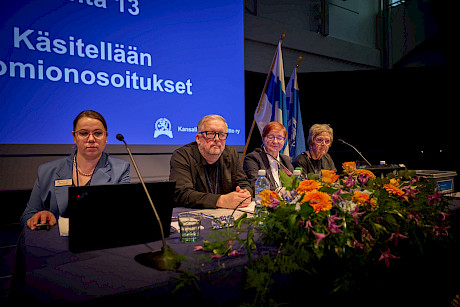 Kokouspöydän takana liittokokouksen toinen puheenjohtaja Jukka Tahvanainen ja sihteeristön edustajia.